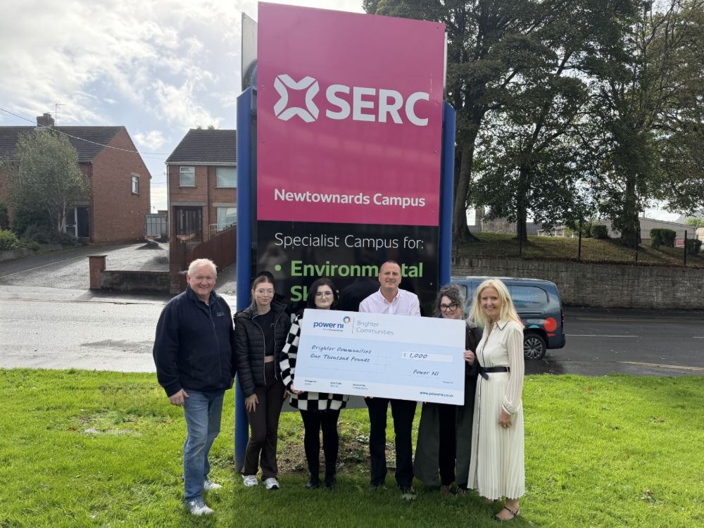 A group of students and staff holding a giant replica cheque at the SERC Newtownards Campus